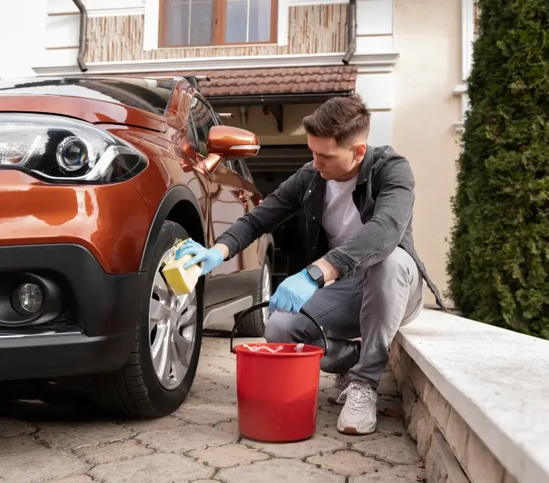 Lavage auto à domicile Saint-Rémy-Boscrocourt : professionnel intervenant sur un véhicule